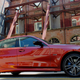 A side photo of the BMW 330e sedan parked behind the shell of an old building.